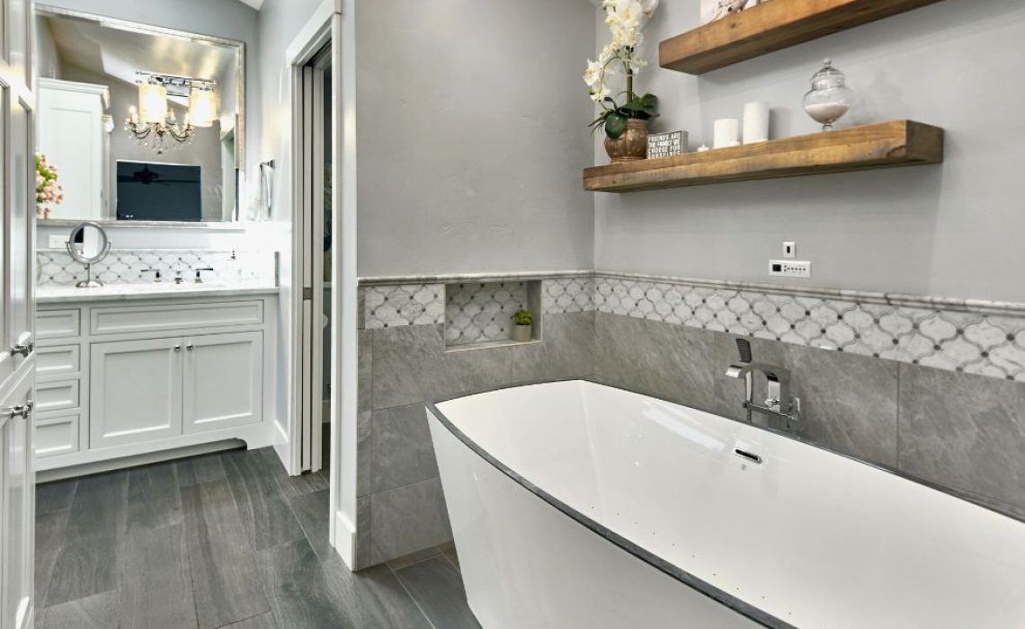View of a modern bathroom renovation with a large tub, sink, and floating shelves