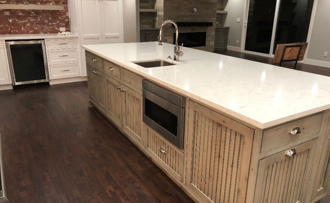 Modern kitchen design with white quartz countertop and dark wood floors