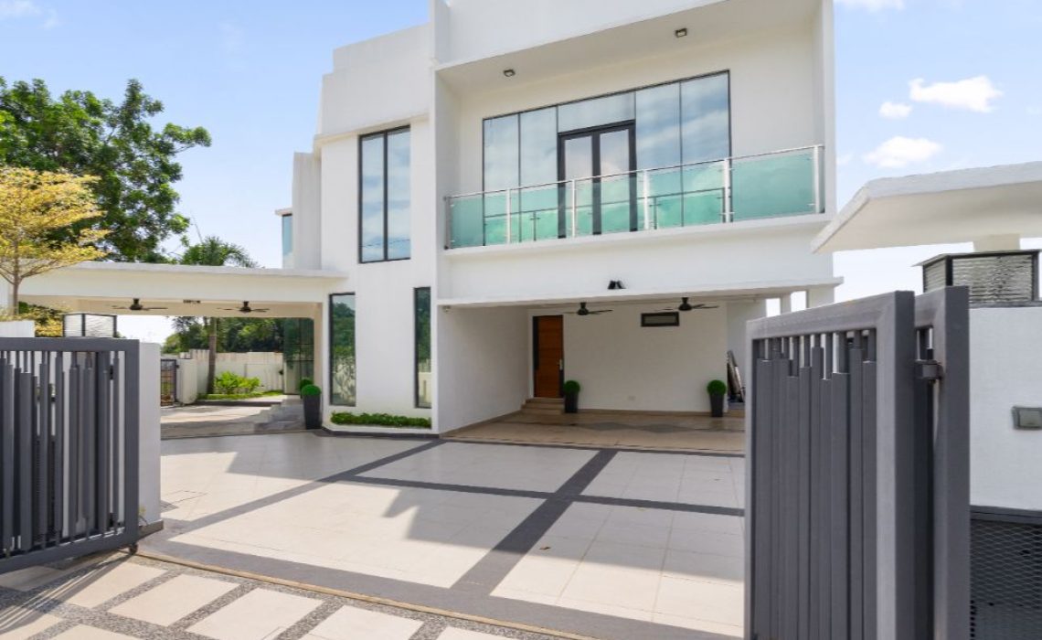 The outside of a home that has a balcony and a garage.