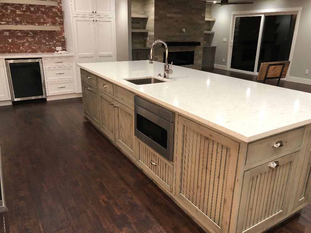 Modern kitchen design with white quartz countertop and dark wood floors